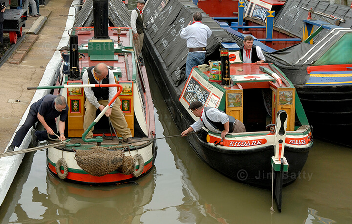 The crew of narrowboat 'President' and butty 'Kildare' tying up at Braunston Marina