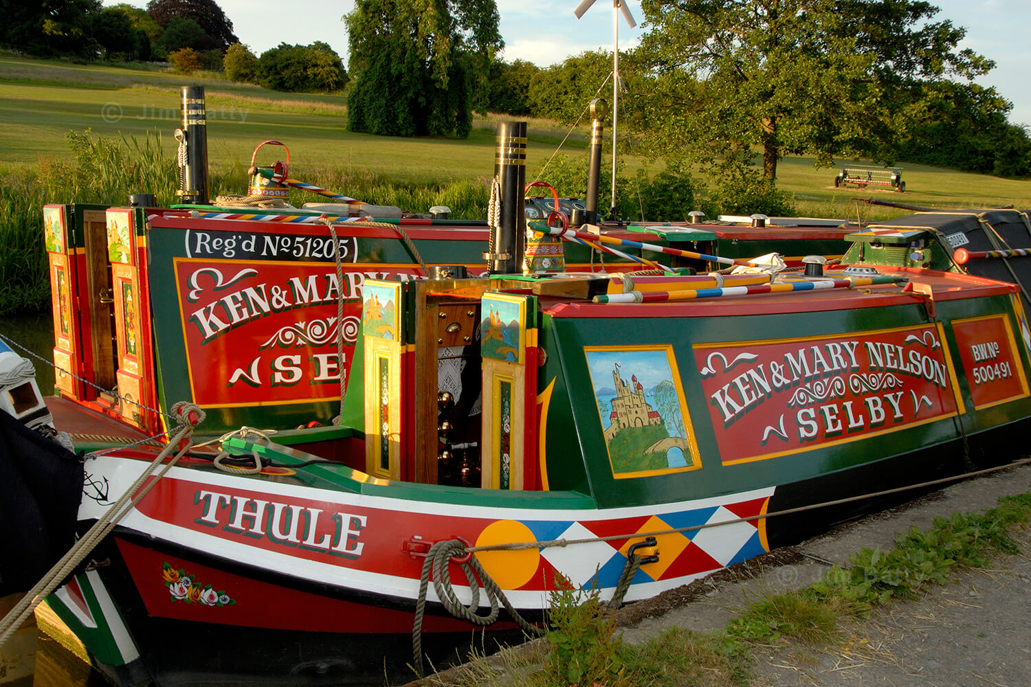 Close-in view of a colourful pair of replica traditional motor and butty liveaboard narrowboats
