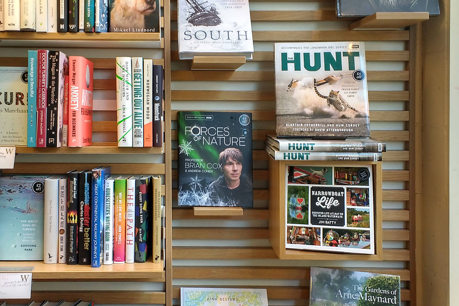 The book 'Narrowboat Life' displayed cover outwards amongst other books in a bookshop