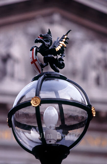 Standing dragon with City of London shield mounted atop glass globe lamp post at the Royal Exchange