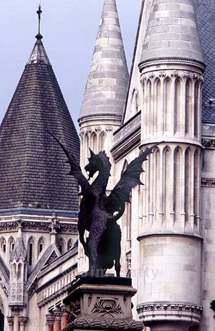 Standing dragon with raised wings against the towers of the Royal Courts of Justice at the old Temple Bar.
