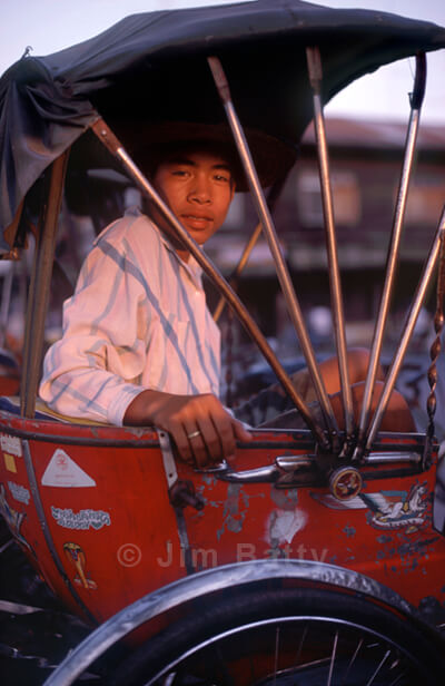 Samlor driver sitting in his cycle rickshaw, Northeast Thailand