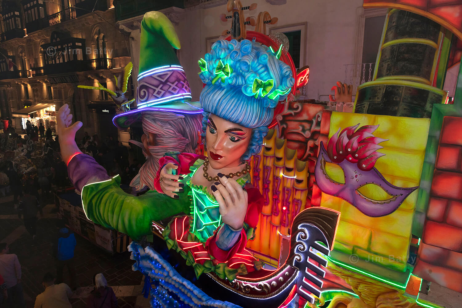 Brightly coloured and illuminated float at night in the streets at the Valetta Carnival: depicting figures in a Venetian gondola