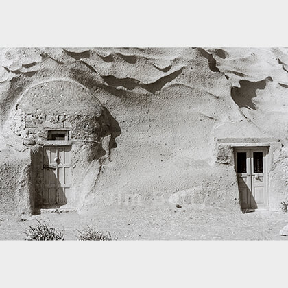 Two doorways appearing from wind- and sea-eroded cliffs, Santorini, Greece